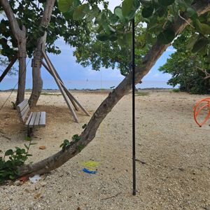 A scenic beachside setting with trees, a bench, and equipment for radio operation visible.