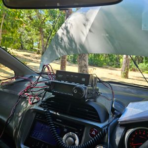 Inside view of a vehicle showing a radio setup with trees in the background.