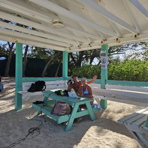 Operators enjoying a POTA activation under a shaded pavilion at the beach.