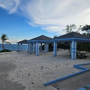Beachside pavilions with a calm ocean view and blue sky.