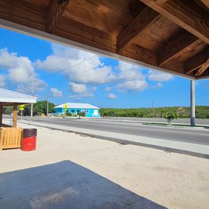 View of a road with a blue building in the background and a partially shaded area in the foreground.