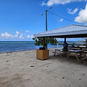 A scenic beachside activation site with a covered pavilion and clear blue water in the background.