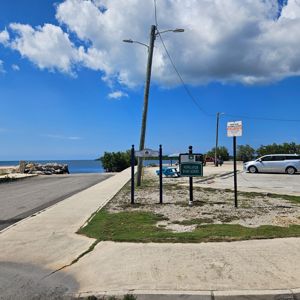 A scenic view at Newlands Bargardere, showing a road leading to a waterfront area with a sign.